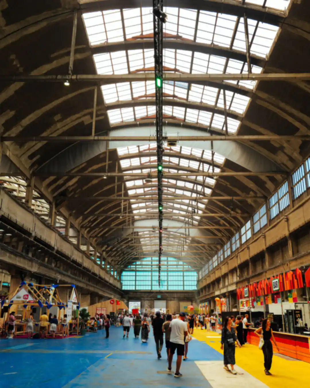 Visitors walking the aisles of a large exhibition hall