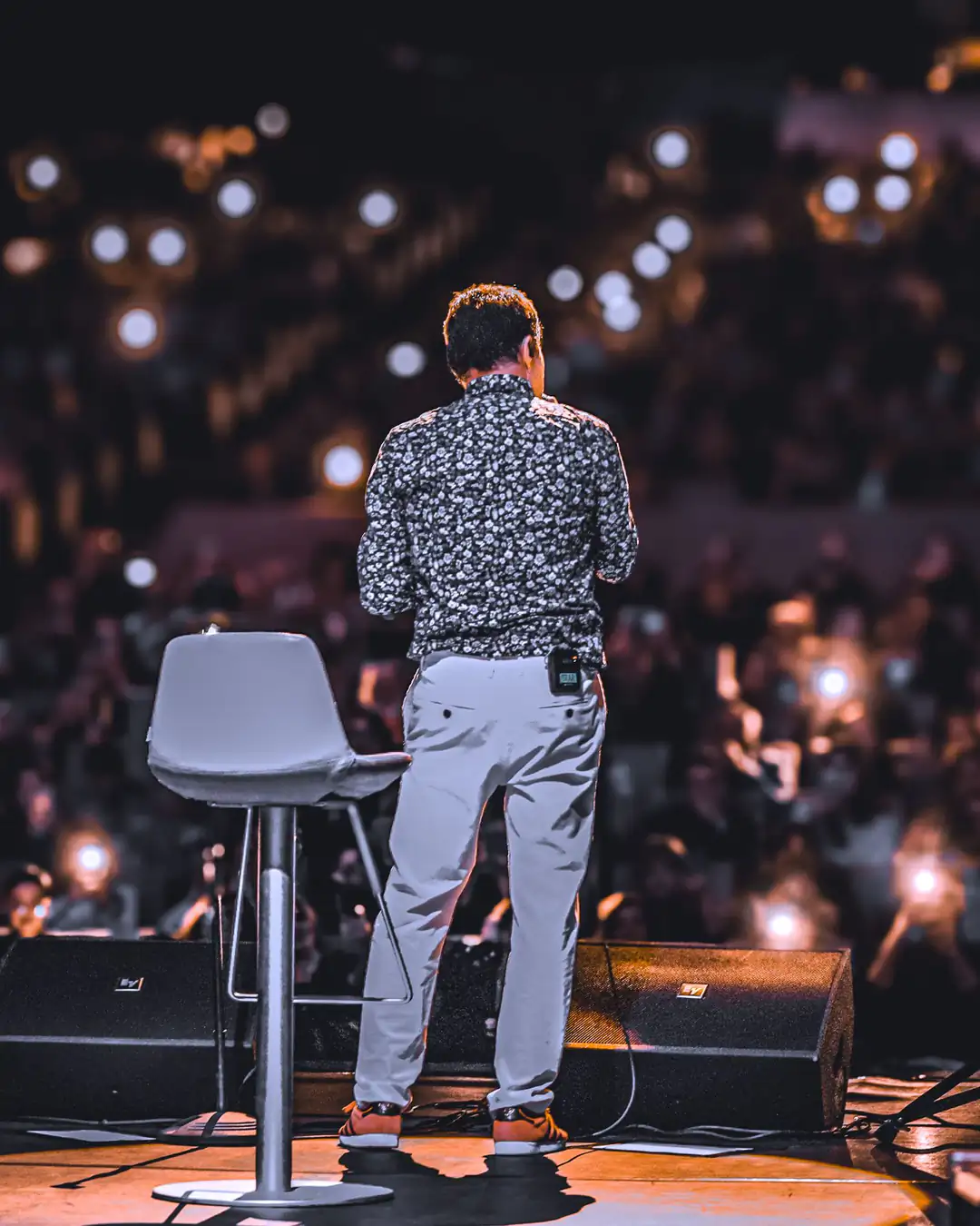 A speaker on stage in front of a full room